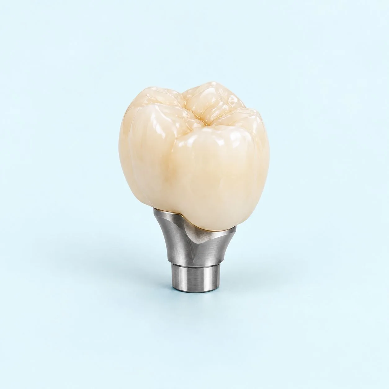 A custom crown seated on its shaped abutment, photographed from the side against a plain ground